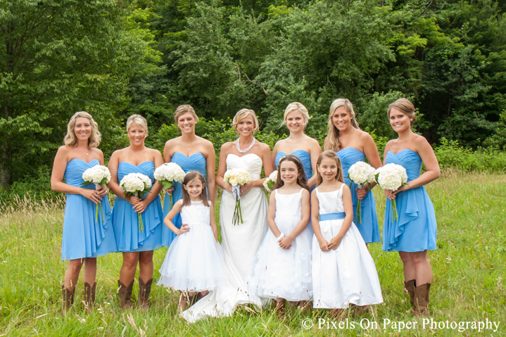Bride and bridesmaids, wedding dress, blue and boots in field at outdoor country mountain wedding at big red barn in west jefferson nc photo