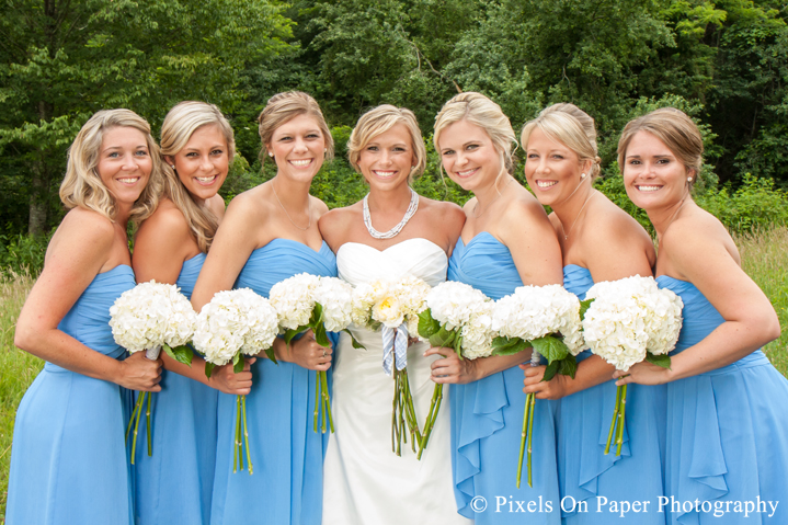 Bride and bridesmaids, wedding dress, blue and boots in field at outdoor country mountain wedding at big red barn in west jefferson nc photo