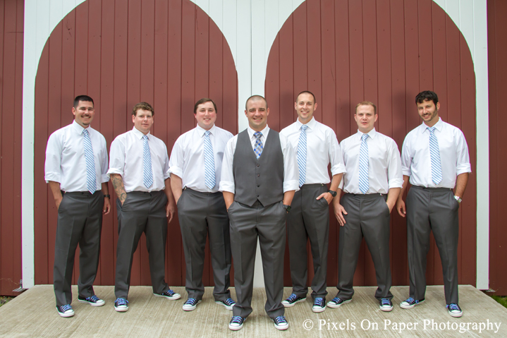 Groom and groomsmen in blue and chuck taylors at outdoor country mountain wedding at big red barn in west jefferson nc photo