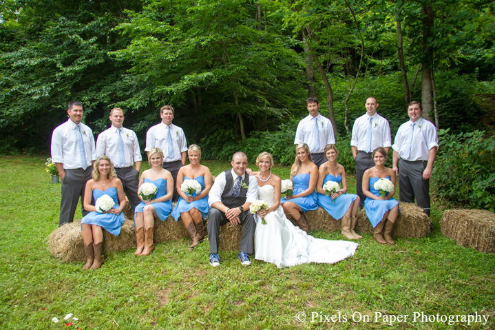 Bride and groom and wedding party on hay bails for wedding photos at outdoor country mountain wedding at big red barn in west jefferson nc photo