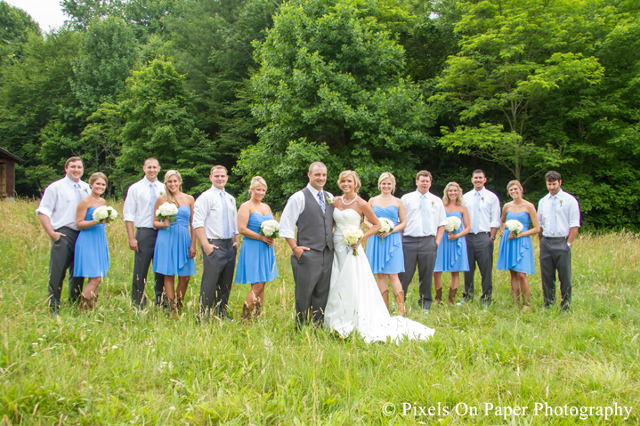 Bride and groom and wedding party in field for wedding photos at outdoor country mountain wedding at big red barn in west jefferson nc photo