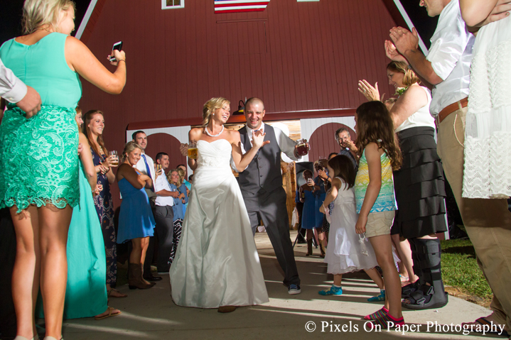 Bride and groom exit at outdoor country mountain wedding at big red barn in west jefferson nc photo