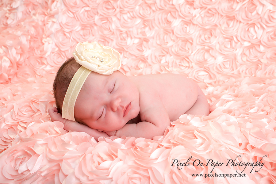Newborn baby portrait by Pixels On Paper Photographers. Baby Scarlett sleeps in pink during newborn portrait session photo.
