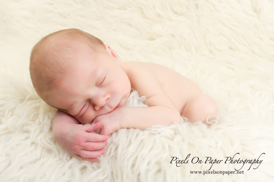 Newborn Baby Portrait Photography by Pixels On Paper Photographers. Baby Liam with eyes closed during his newborn session photo.
