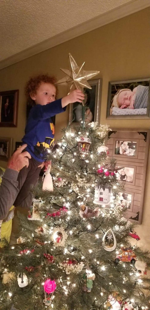Finley placing the star on the Christmas tree photo