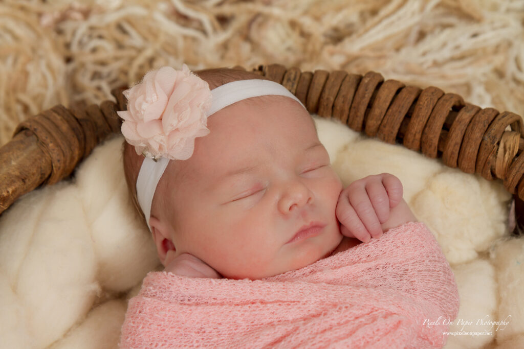 Newborn Lucy swaddled in blush pink, photographed by Pixels On Paper, a newborn photographer in Wilkesboro NC.