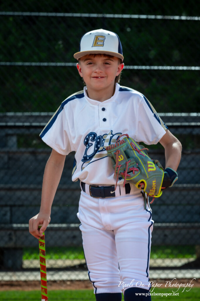 Portrait of NWNC Elite 8U baseball player smiling in uniform holding glove
