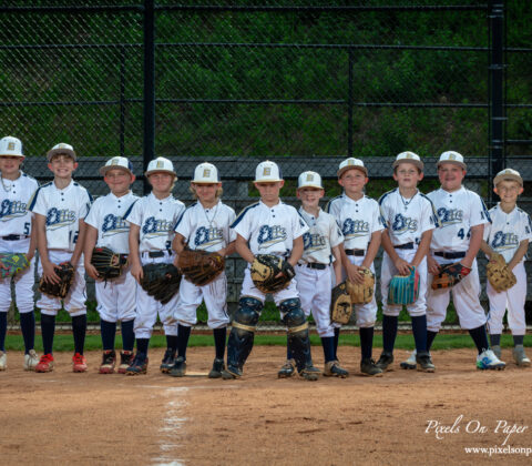 NWNC Elite 8U baseball team posing together on the diamond in uniforms