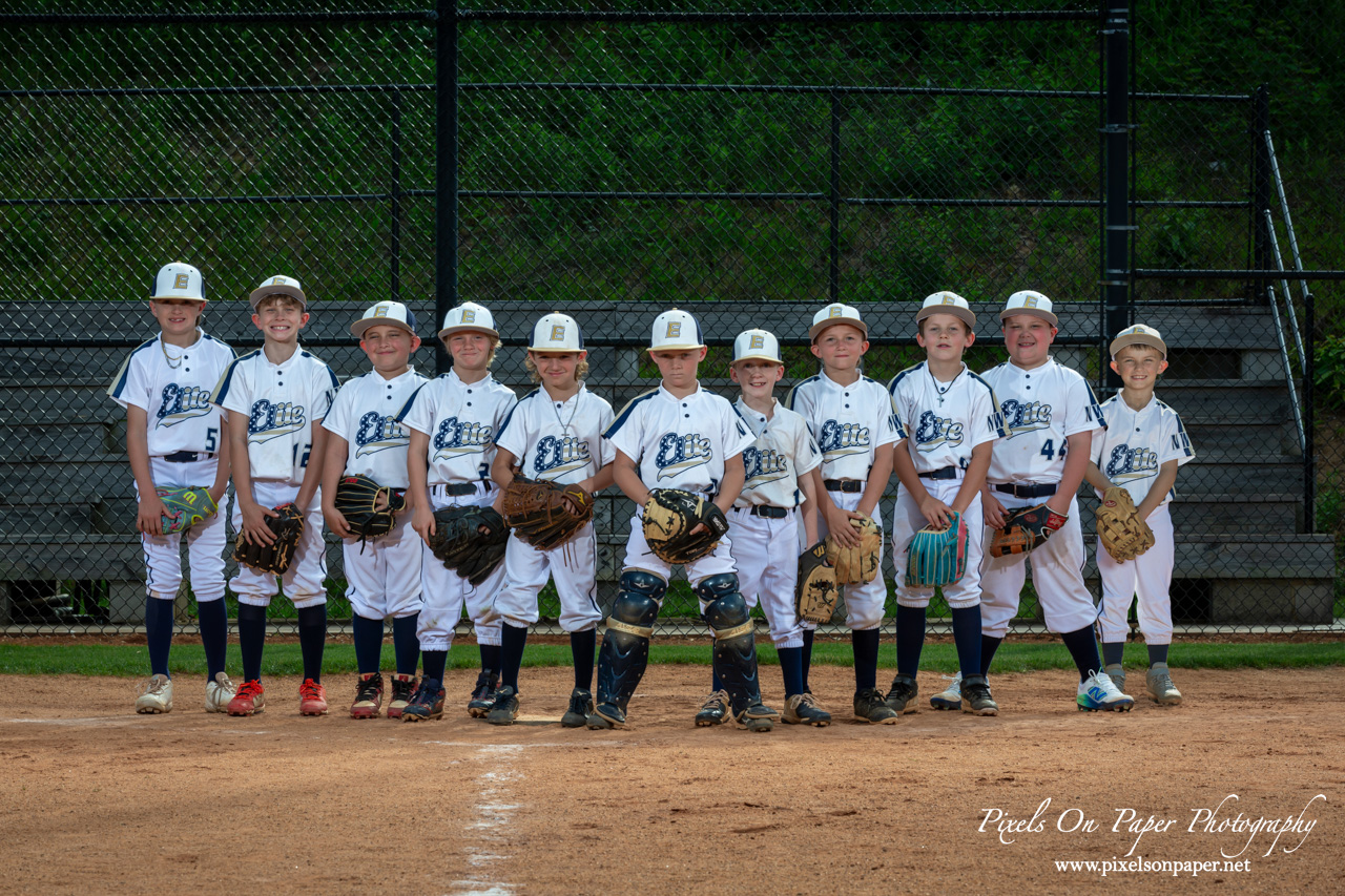 NWNC Elite 8U baseball team posing together on the diamond in uniforms